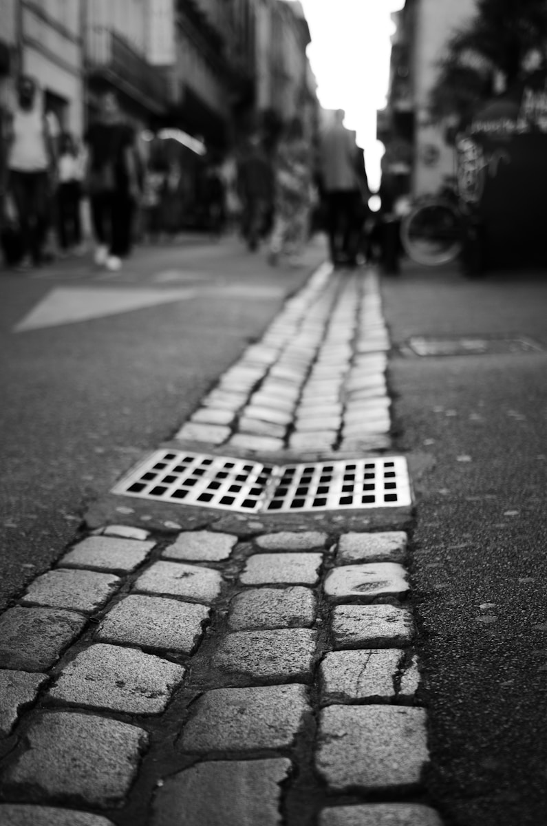 a sidewalk with a drain